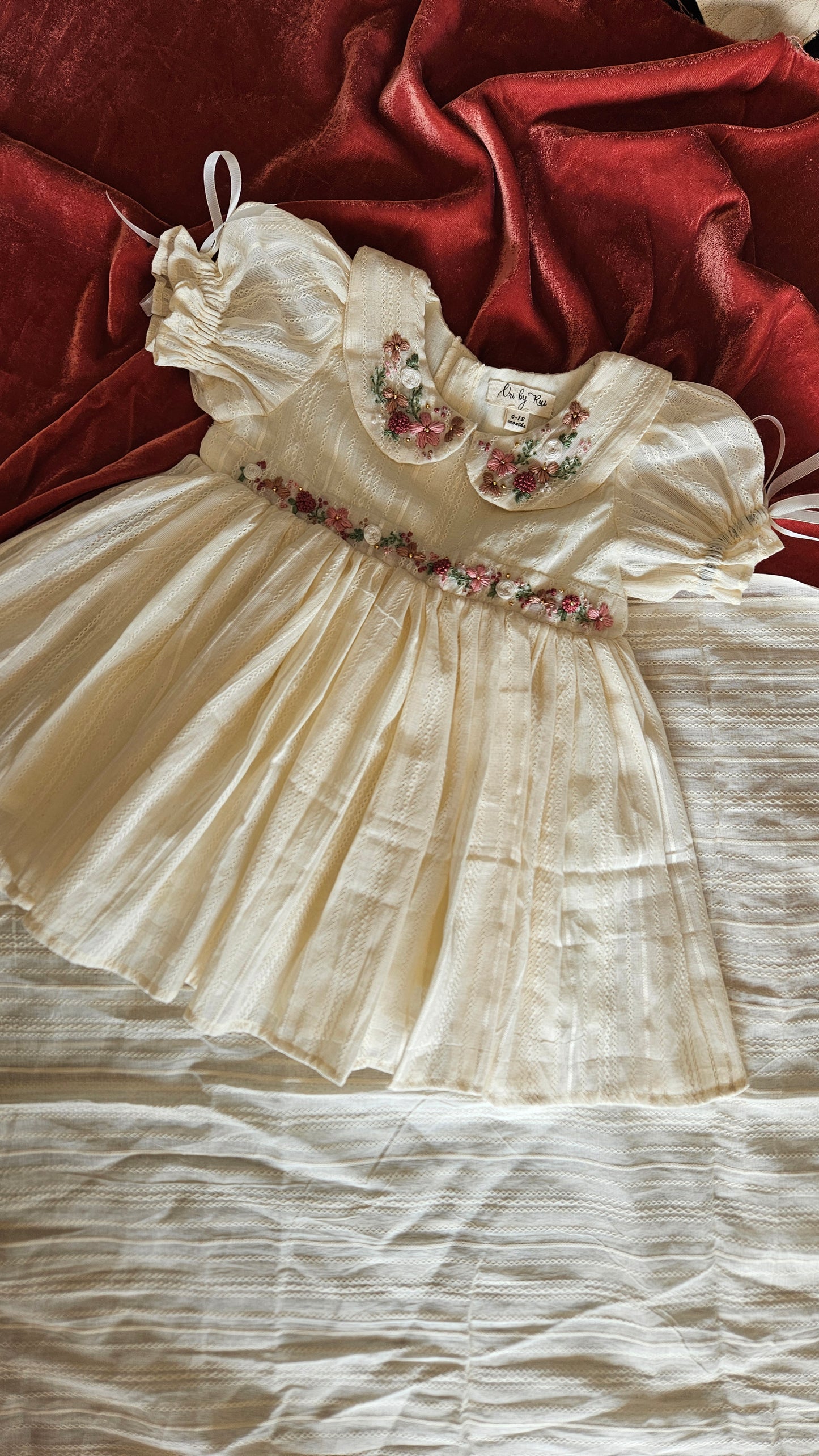 Flatlay of ivory Angel in Heaven dress showing floral embroidery