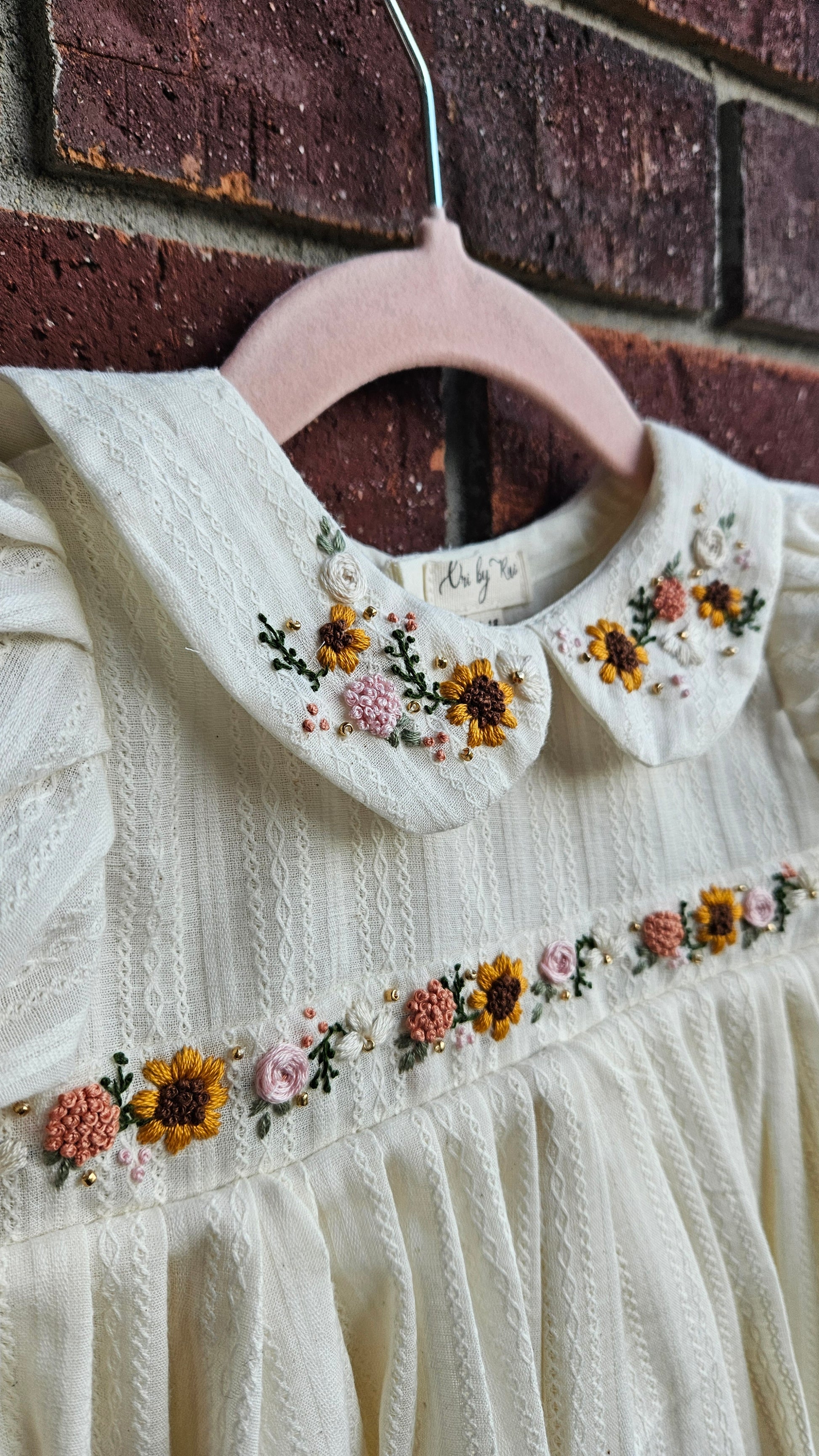 “Ivory baby dress with hand-embroidered sunflowers, roses, and puff sleeves – Rui.cares”