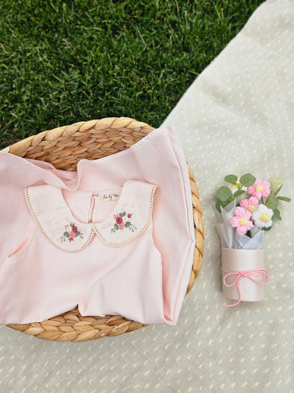 A baby pink cotton linen A-line dress for girls featuring a hand-embroidered Peter Pan collar with delicate pink floral embroidery and scalloped trim. The sleeveless dress has a classic silhouette, making it perfect for birthdays, festive occasions, family outings, and special celebrations.
