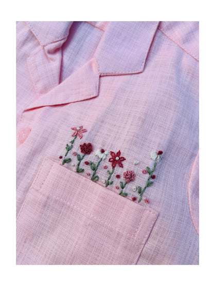 Close-up of hand-embroidered floral pocket on pink Bubble Gum boys’ shirt.