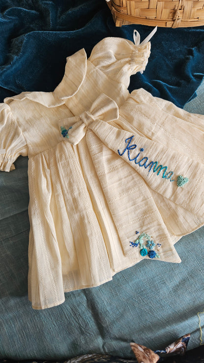 Ivory baby dress with blue hand-embroidered flowers – Oceano Angel Dress by Rui.cares