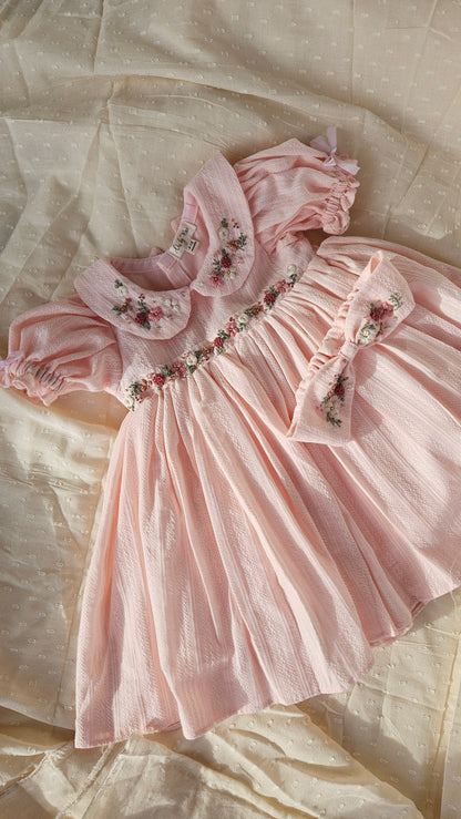 Flatlay of Peachy Peep dress showing floral embroidery and matching bow.